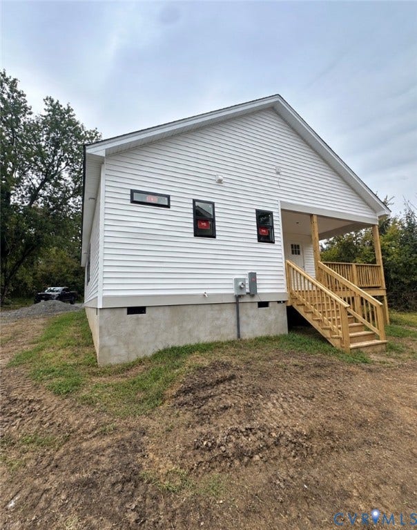 Exterior featuring white horizontal siding, a concrete foundation, dark-framed windows, and a raised wood-deck porch with matching railings