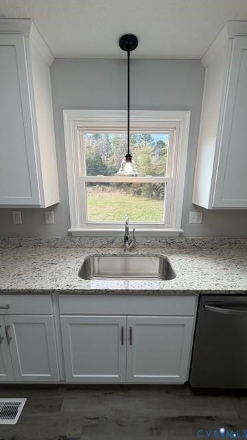 White shaker cabinetry, stainless steel basin sink, gray speckled countertops, dark wood-finish flooring, and a contemporary pendant light fixture