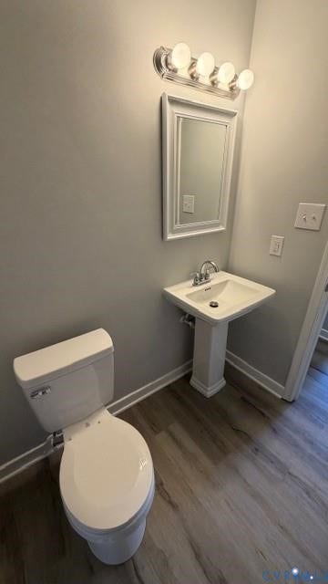 Pedestal sink with chrome fixtures, framed mirror, and a contemporary four-bulb vanity light