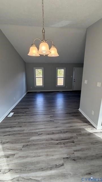 Vaulted ceiling with a chandelier, wood-finish flooring, and light gray wall paint