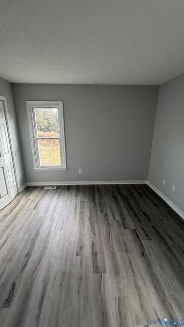 Wood-finish flooring with a neutral wall color, white trim, and a window