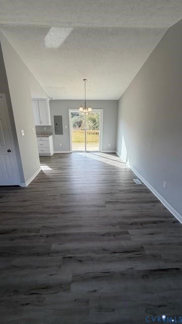 Vaulted ceiling, wood-finish flooring, sliding glass door, overhead lighting, white cabinetry