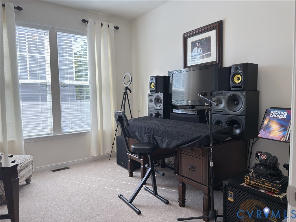 Neutral interior room featuring dual windows with horizontal blinds and wall-to-wall carpeting