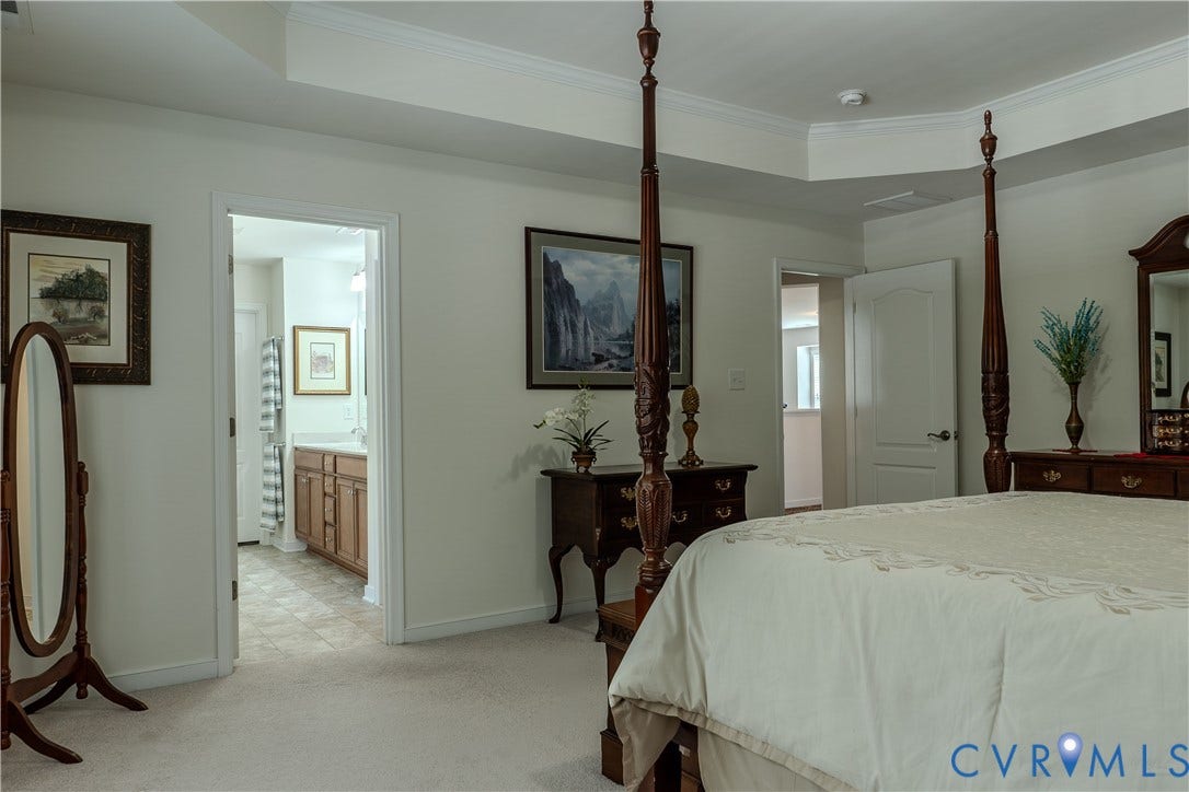 Tray ceiling featuring crown molding and neutral wall tones