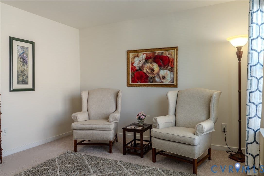 Neutral-toned interior space featuring light-colored wall paint and wall-to-wall carpeting