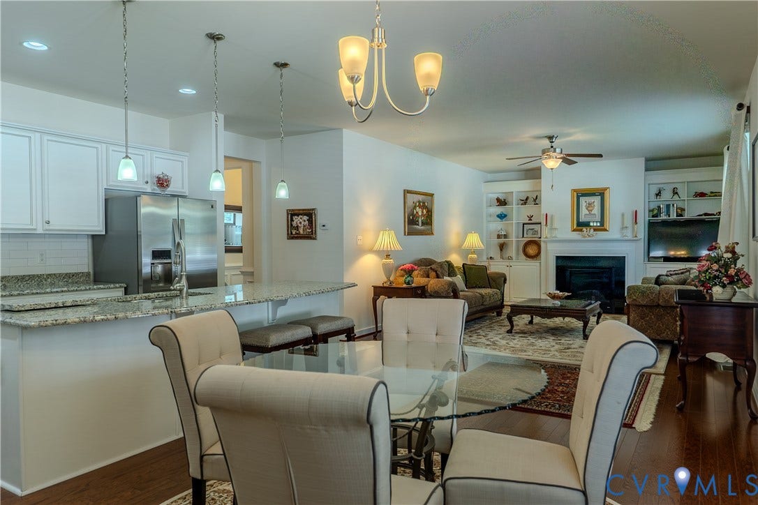 Kitchen featuring a stone countertop peninsula, white shaker-style cabinetry, stainless steel refrigerator, recessed lighting, and wood-finish flooring throughout