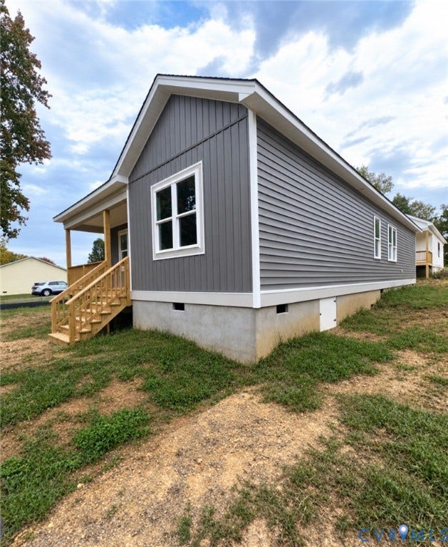 Gray vinyl siding exterior featuring vertical board-and-batten accents, white trim, a gabled roofline, and a covered front porch with wooden stairs