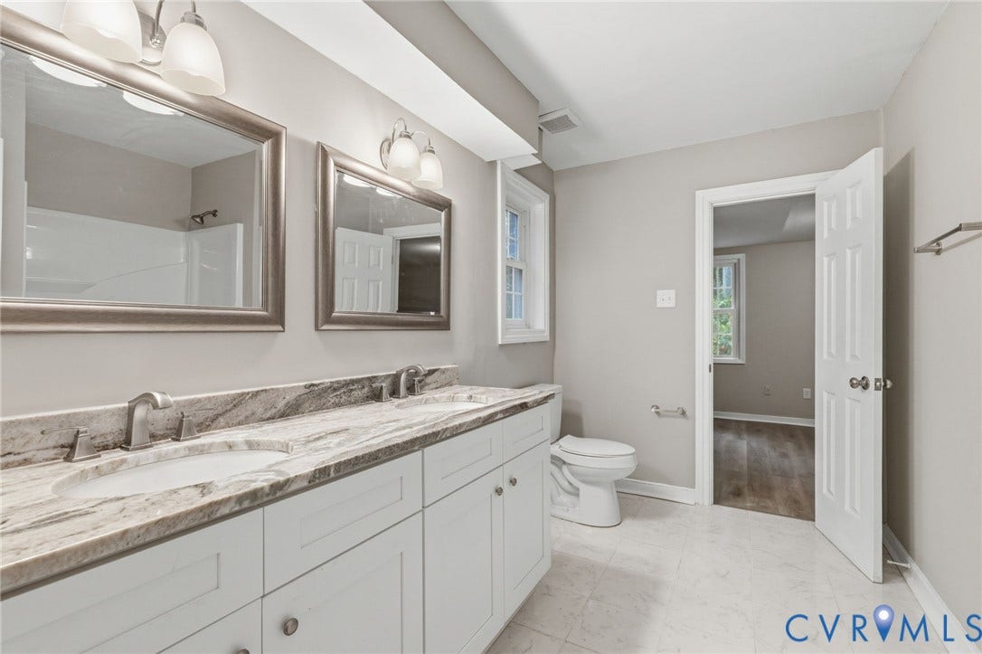 10731 Spring Run Road, Manchester, Chesterfield, VA 23832 Double vanity with undermount sinks, stone countertop, two framed mirrors, and a shower/tub combination