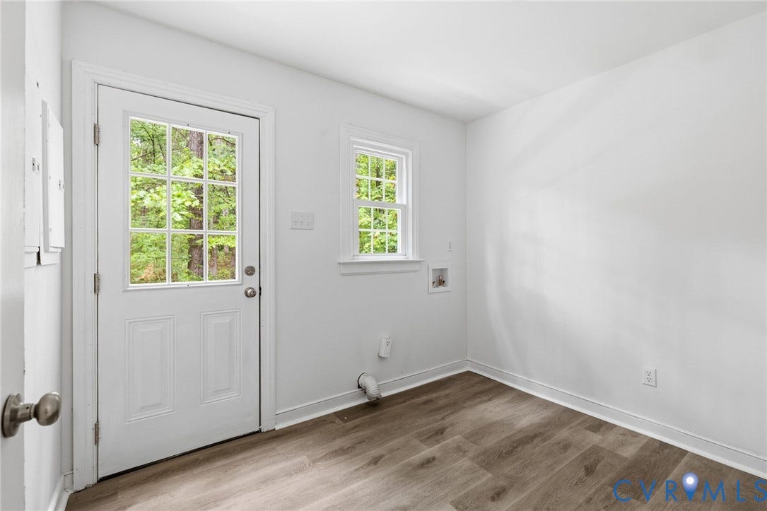 10731 Spring Run Road, Manchester, Chesterfield, VA 23832 Wood-finish flooring with white baseboards, a white paneled door with windowpanes, and a single window with white trim