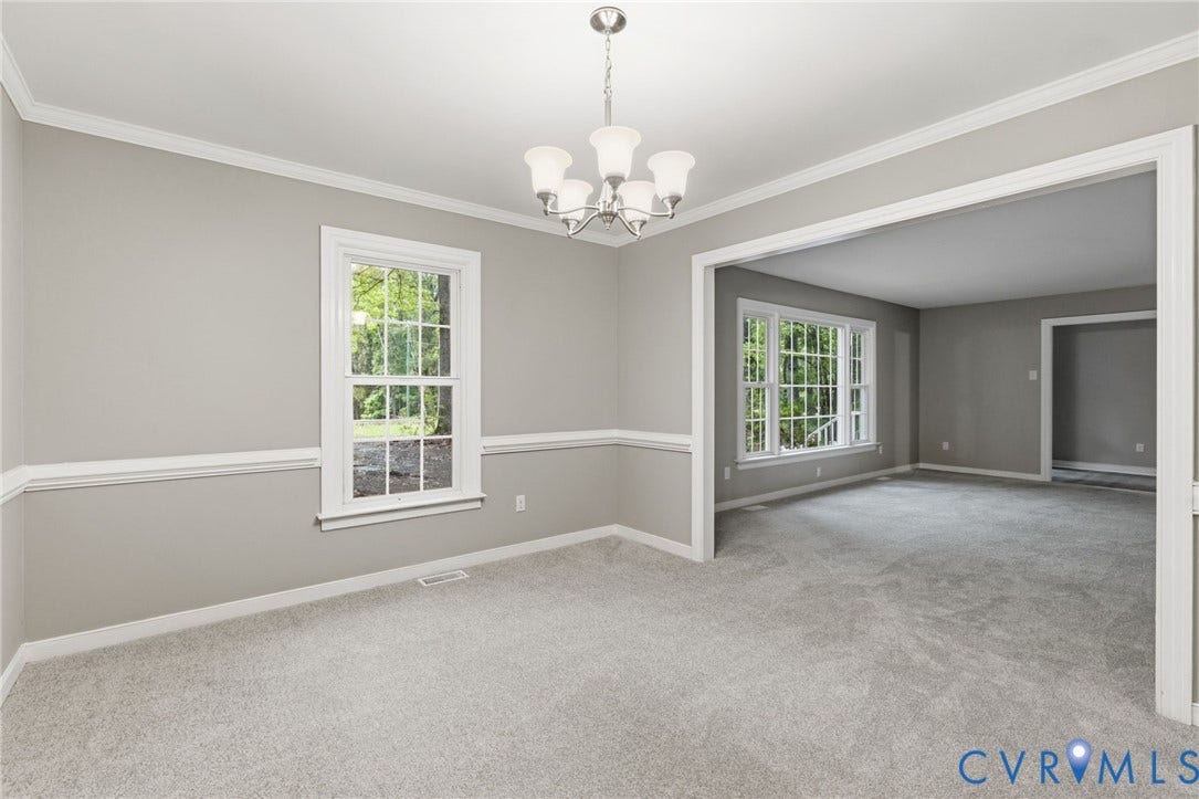 10731 Spring Run Road, Manchester, Chesterfield, VA 23832 Recessed lighting, crown molding, chair rail molding, and a chandelier illuminate this carpeted room with multiple windows