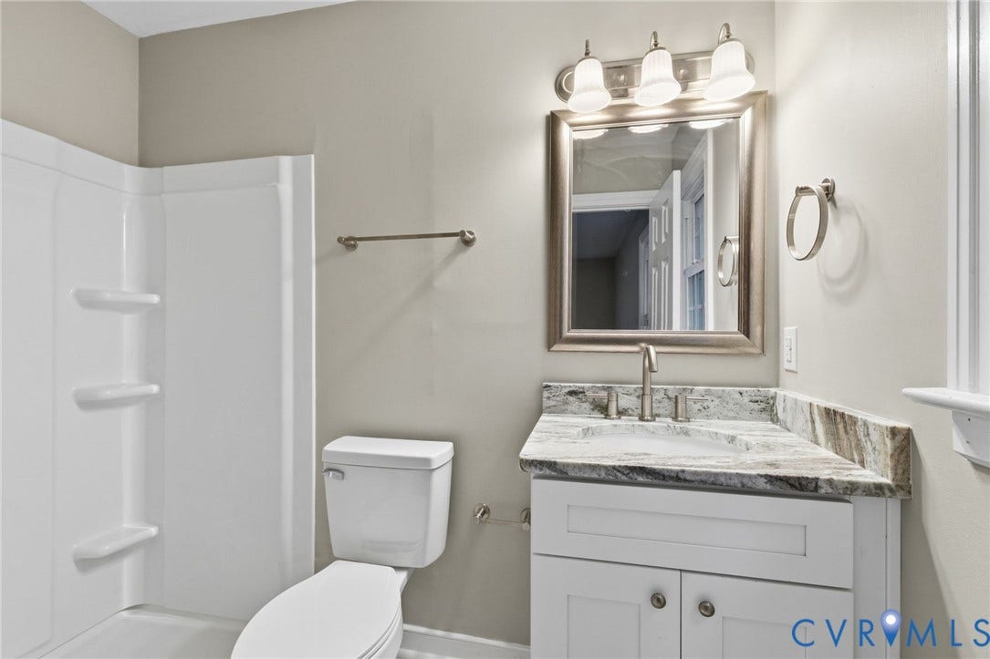 10731 Spring Run Road, Manchester, Chesterfield, VA 23832 White vanity with a stone countertop, under-mount sink, and brushed nickel faucet
