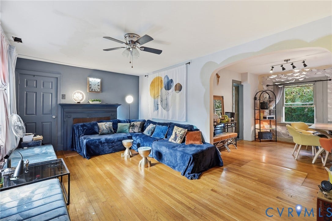 Hardwood flooring, arched doorway, ceiling fan, recessed lighting, and a window with outdoor scenery