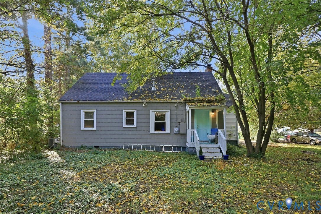 Gabled roof residence featuring gray siding, white trim windows, and a covered front porch with white railings