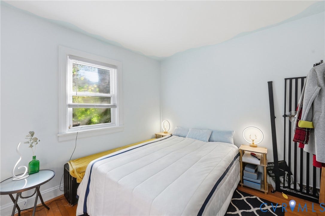Hardwood flooring, light-colored walls, and a window with blinds