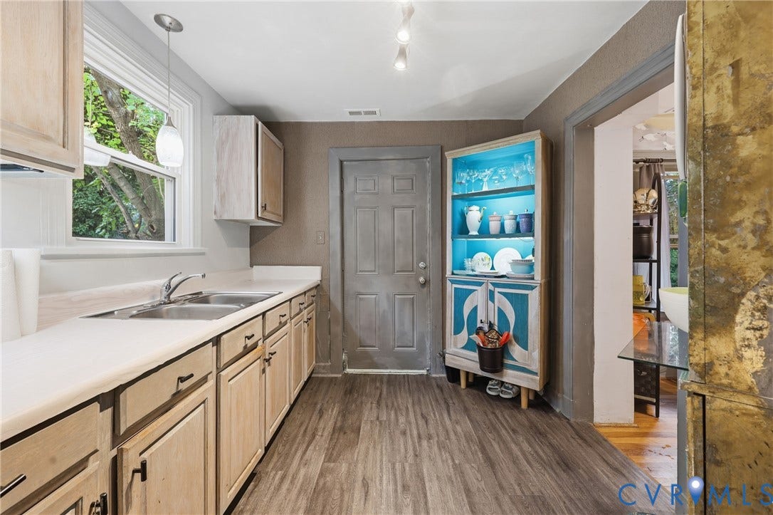 Kitchen featuring wood-finish flooring, light-toned cabinetry, stainless steel double sink, pendant lighting, and recessed lighting