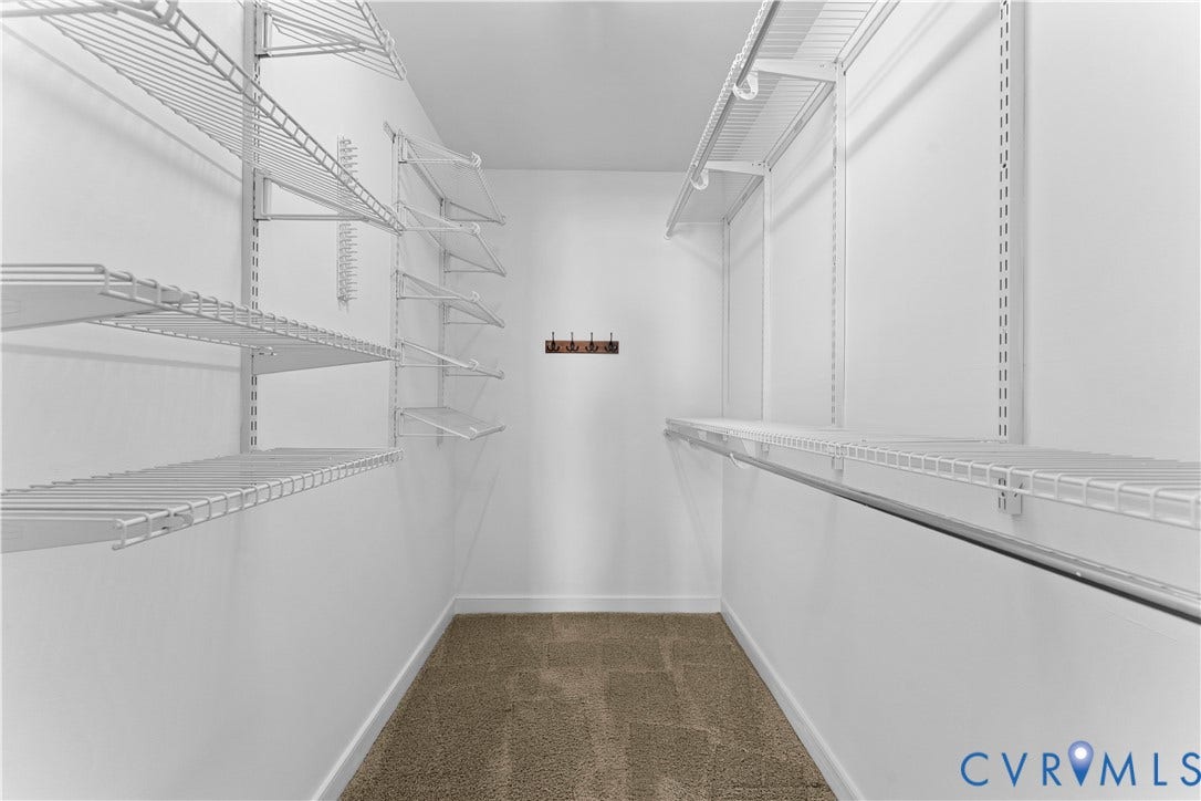 2307 Garrison Place Terrace, Garrison Place, Midlothian, VA 23112 Walk-in closet featuring floor-to-ceiling white wire shelving, wall-mounted hanging rods, neutral carpeting, and an attached multi-hook rack