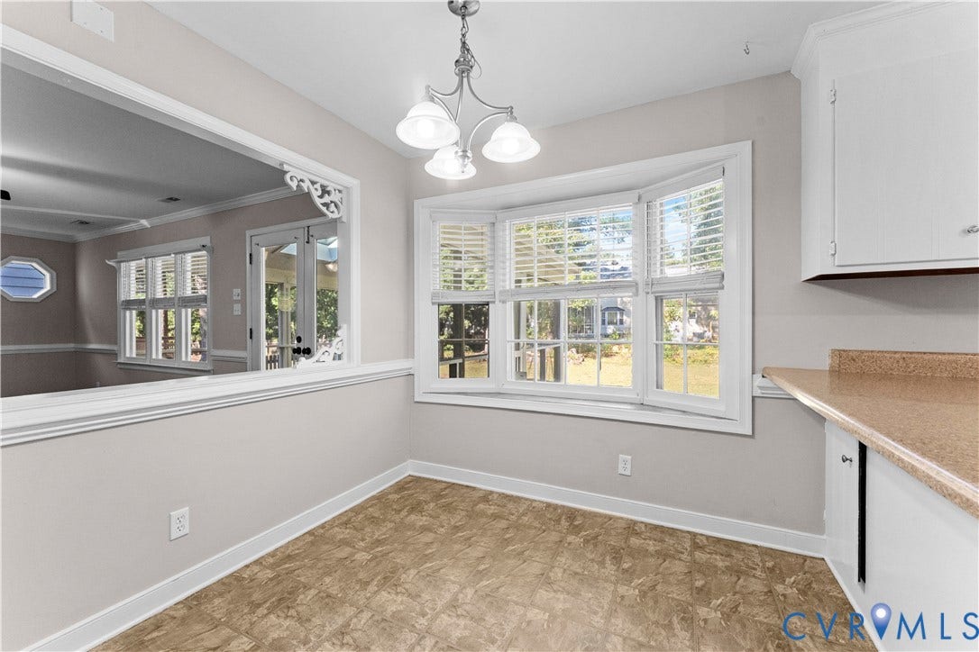 2307 Garrison Place Terrace, Garrison Place, Midlothian, VA 23112 Bay window with natural light, pass-through opening with decorative corbels, three-light chandelier, and built-in cabinetry with stone-finish countertops