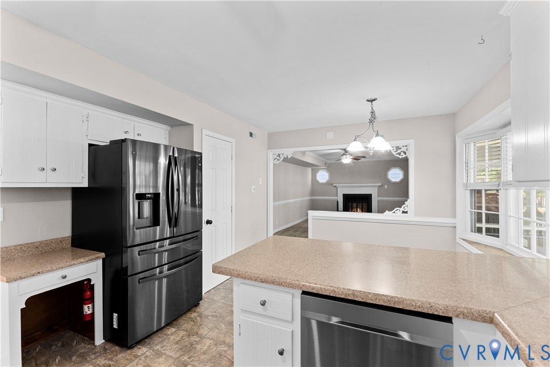 2307 Garrison Place Terrace, Garrison Place, Midlothian, VA 23112 Kitchen featuring white cabinetry, solid-surface countertops, stainless steel appliances, a multi-pane bay window, and a decorative cased opening