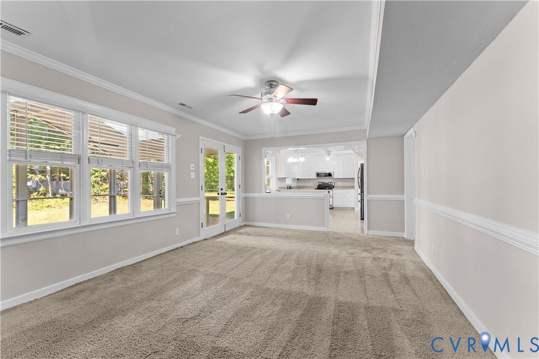 2307 Garrison Place Terrace, Garrison Place, Midlothian, VA 23112 Interior space featuring neutral-toned carpeting, crown molding, chair rail trim, a multi-blade ceiling fan, and large windows with integrated blinds
