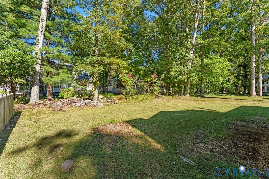 2307 Garrison Place Terrace, Garrison Place, Midlothian, VA 23112 Expansive backyard featuring a lawn, mature canopy trees, and a wooden perimeter fence