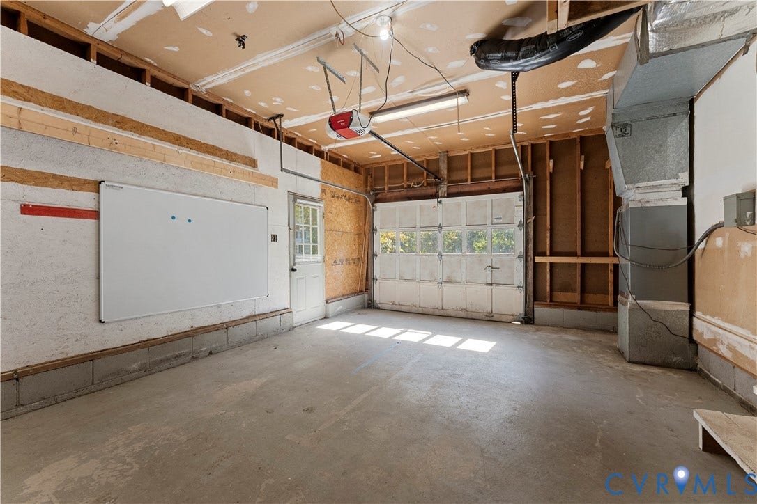 2307 Garrison Place Terrace, Garrison Place, Midlothian, VA 23112 Garage space featuring a concrete floor, windowed sectional door, exterior access door, and exposed wall framing