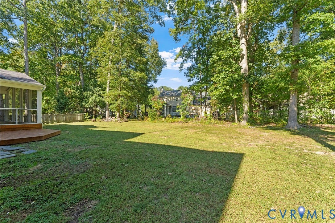 2307 Garrison Place Terrace, Garrison Place, Midlothian, VA 23112 Spacious backyard featuring a grass lawn, mature trees, a wooden deck, and a screened-in enclosure