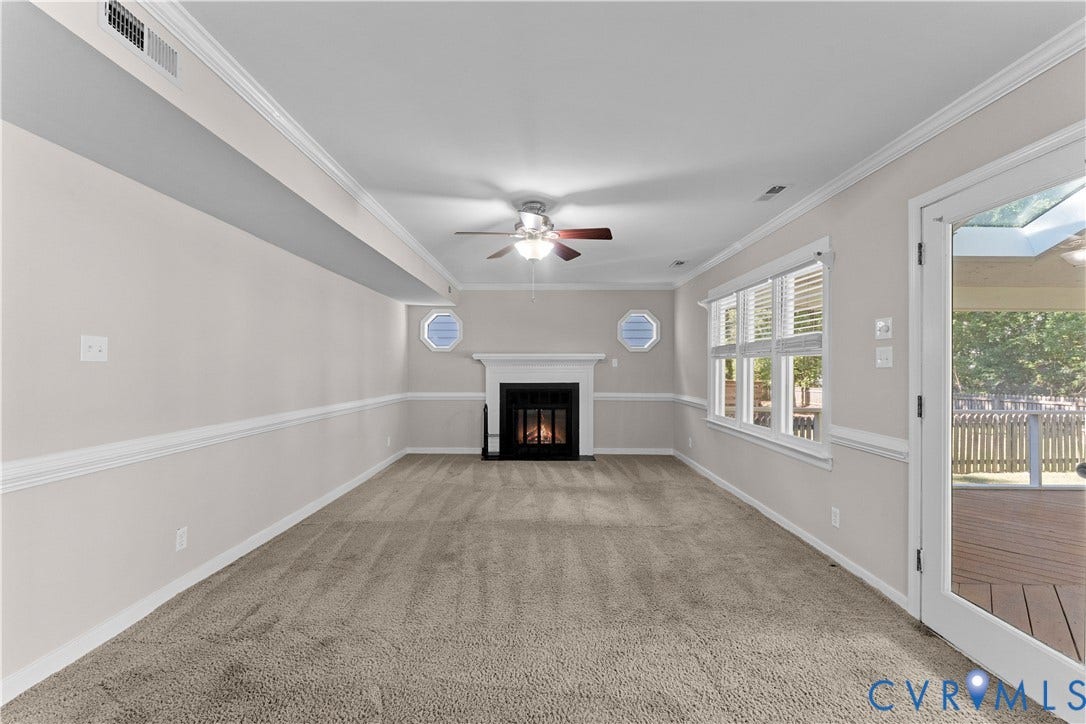 2307 Garrison Place Terrace, Garrison Place, Midlothian, VA 23112 Fireplace with a white mantel, neutral wall-to-wall carpeting, crown molding, chair rail trim, and glass-paned door opening to an exterior deck