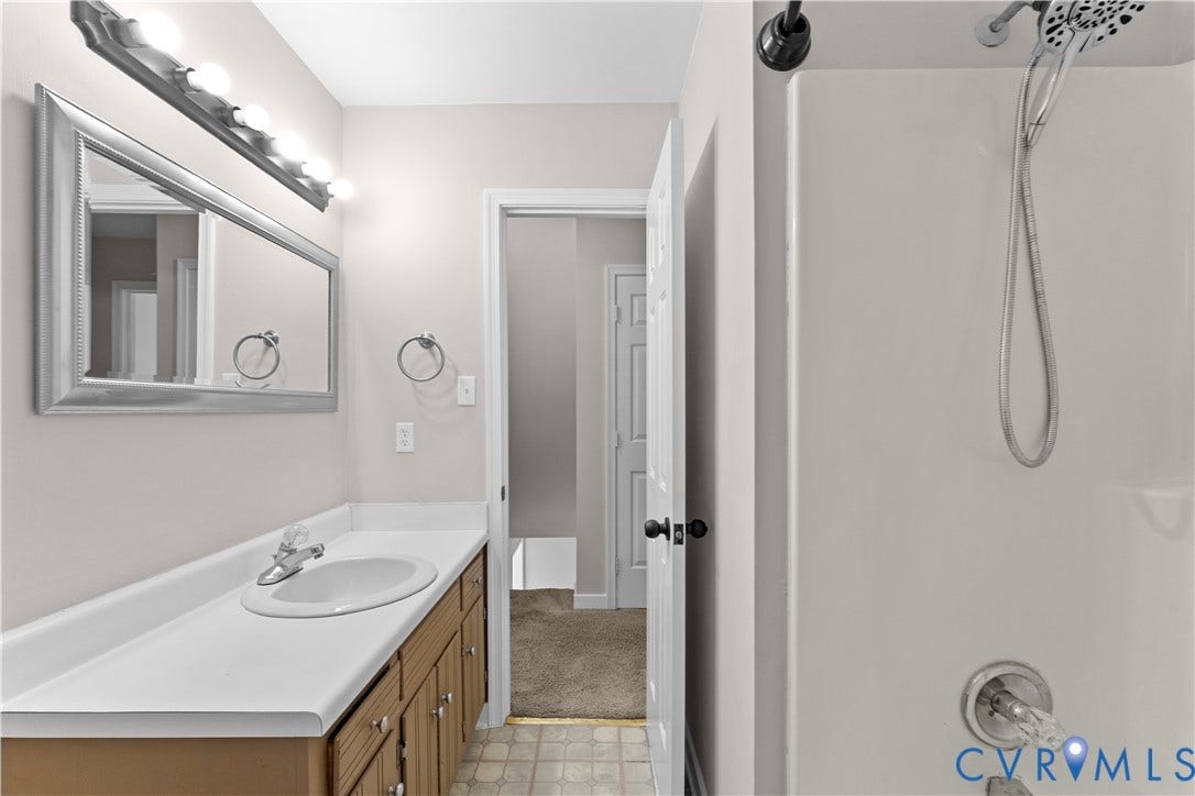 2307 Garrison Place Terrace, Garrison Place, Midlothian, VA 23112 Bathroom featuring a vanity with a white integrated countertop and sink, large wall-mounted mirror, multi-bulb overhead light fixture, and a shower with a handheld showerhead