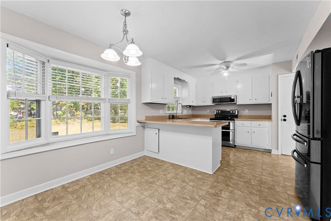 2307 Garrison Place Terrace, Garrison Place, Midlothian, VA 23112 Kitchen featuring white cabinetry, a peninsula, stainless steel appliances, tiled flooring, and a triple-pane bay window