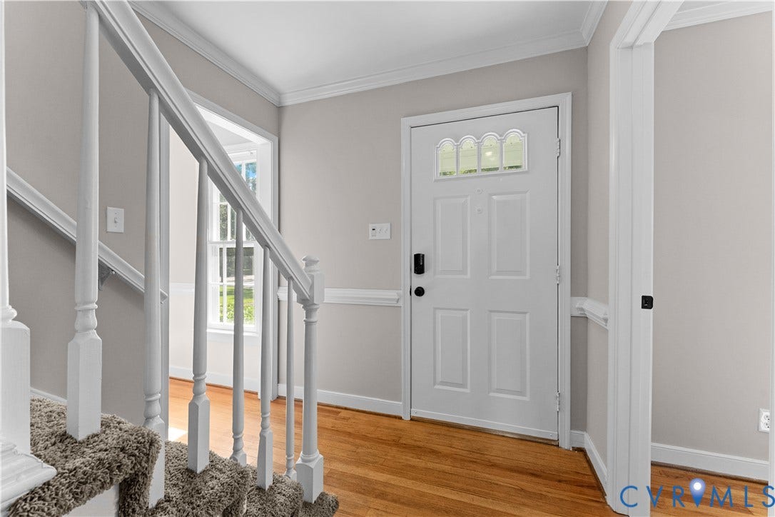 2307 Garrison Place Terrace, Garrison Place, Midlothian, VA 23112 Foyer featuring wood-finish flooring, white paneled entry door with arched transom glass, staircase with white spindle balusters, and wainscoting