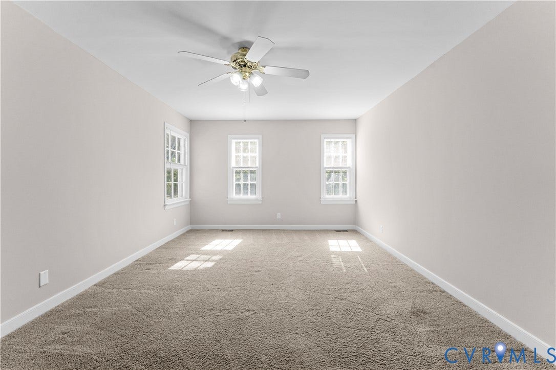 2307 Garrison Place Terrace, Garrison Place, Midlothian, VA 23112 Neutral-toned interior space featuring wall-to-wall carpeting, three multi-pane windows, and a central ceiling fan with integrated lighting
