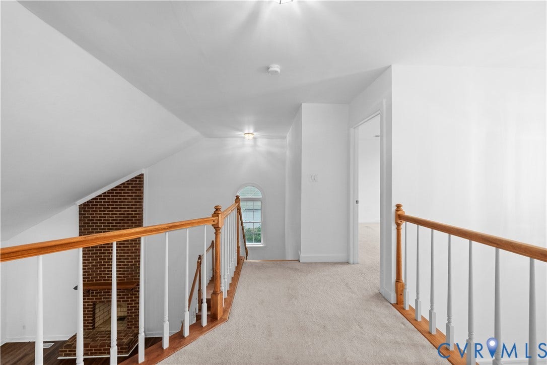 3437 Riverton Court, Robious Road Corridor, Midlothian, VA 23113 Neutral-toned carpet flooring, arched window, brick chimney breast, and wooden handrail with white balusters
