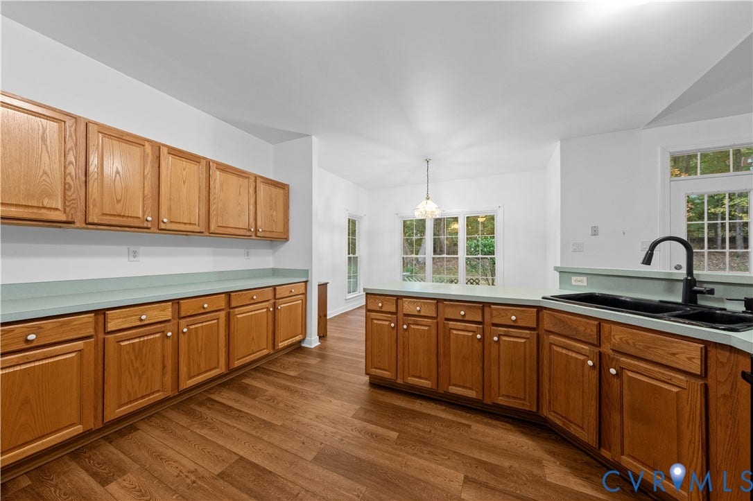 3437 Riverton Court, Robious Road Corridor, Midlothian, VA 23113 Kitchen featuring natural wood cabinetry, wood-finish flooring, solid-surface countertops, a double-basin sink with a matte black faucet, and a decorative pendant light