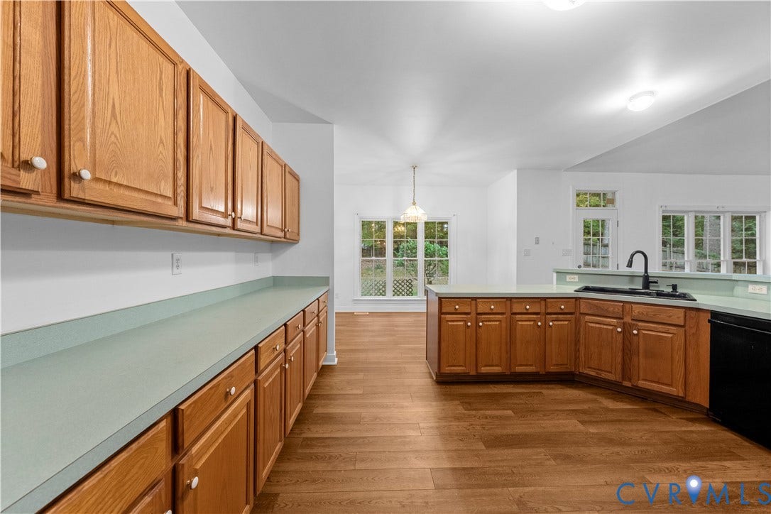 3437 Riverton Court, Robious Road Corridor, Midlothian, VA 23113 Kitchen featuring wood cabinetry, laminate countertops, wood-finish flooring, a dual-basin sink with a matte black faucet, and expansive windows