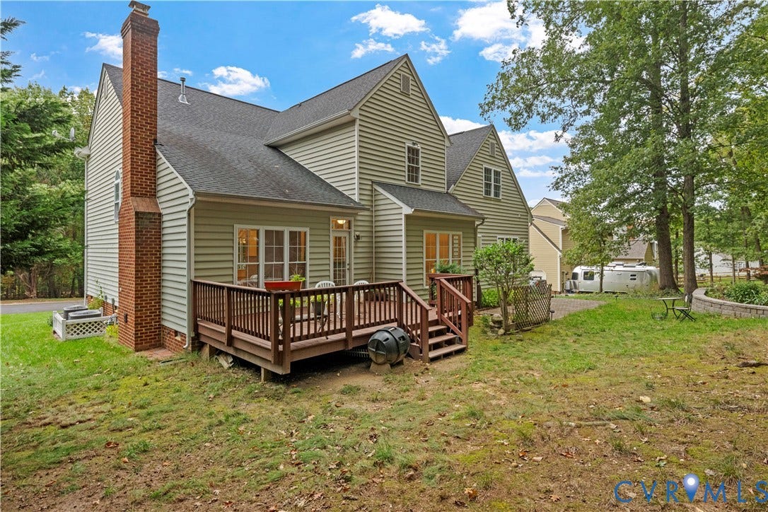 3437 Riverton Court, Robious Road Corridor, Midlothian, VA 23113 Rear exterior featuring light-colored horizontal siding, a multi-story roofline, a full-height brick chimney, and an elevated wood deck