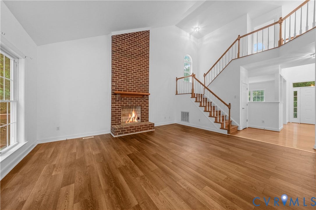 3437 Riverton Court, Robious Road Corridor, Midlothian, VA 23113 Vaulted ceiling, floor-to-ceiling brick fireplace with wood mantel, wood-finish flooring, and staircase featuring a wooden handrail and balusters