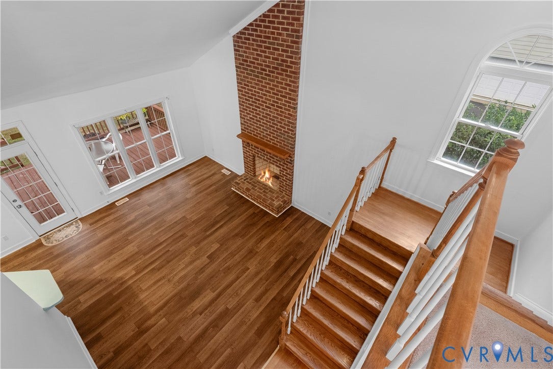 3437 Riverton Court, Robious Road Corridor, Midlothian, VA 23113 Vaulted ceilings, floor-to-ceiling brick fireplace with a wood mantel, wood-finish flooring, staircase with wood handrails and white balusters, and arched windows