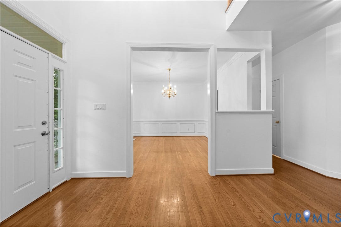 3437 Riverton Court, Robious Road Corridor, Midlothian, VA 23113 Foyer with high ceilings, wood-finish flooring, paneled entry door with glass sidelights, and classic chandelier lighting, featuring wainscoting detail
