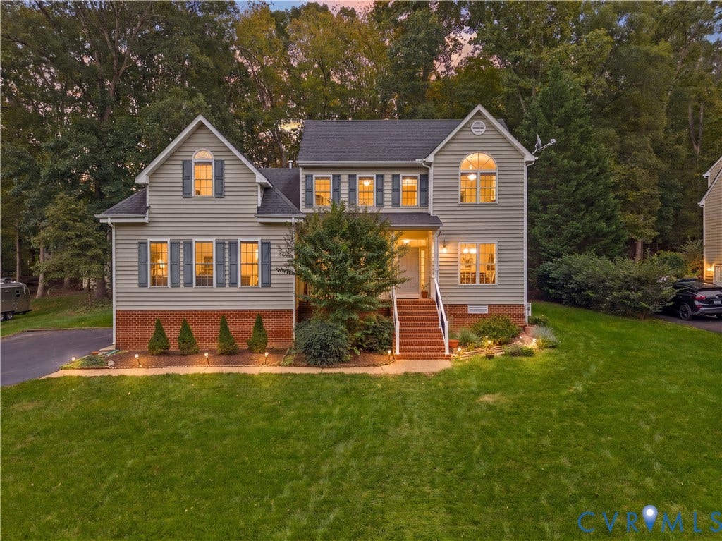 3437 Riverton Court, Robious Road Corridor, Midlothian, VA 23113 Two-story residence featuring light-colored horizontal siding, brick foundation masonry, a covered front entry with steps, arched window detailing, and dark-toned exterior shutters