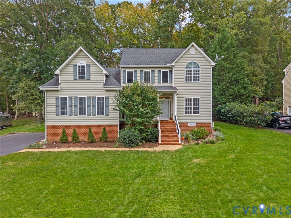 3437 Riverton Court, Robious Road Corridor, Midlothian, VA 23113 Two-story residence featuring light-toned horizontal siding, a red brick veneer base, shingled roofing, multi-pane windows with shutters, and a brick-stair entryway