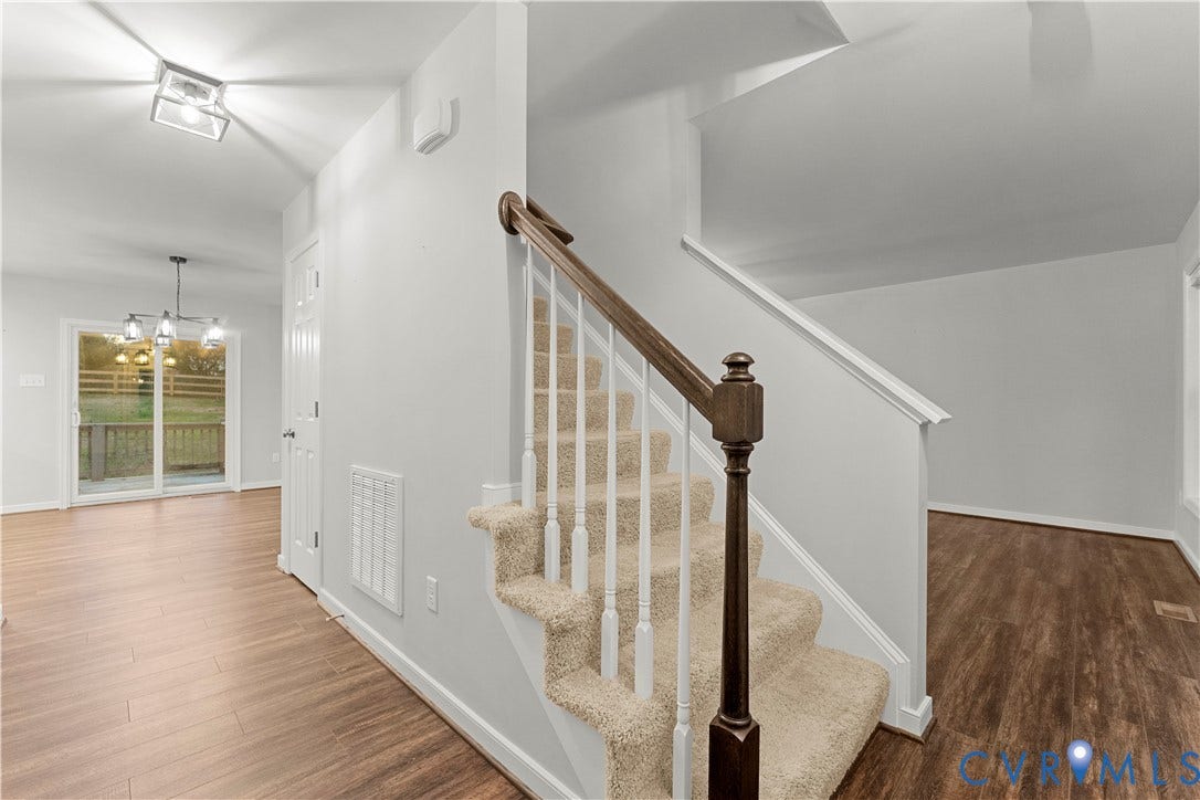 2953 Preston Park Court, Western Goochland County, Goochland, VA 23153 Wood-finish flooring, white paneled door with glass inserts, and a staircase featuring a dark wood newel post and handrail with white balusters