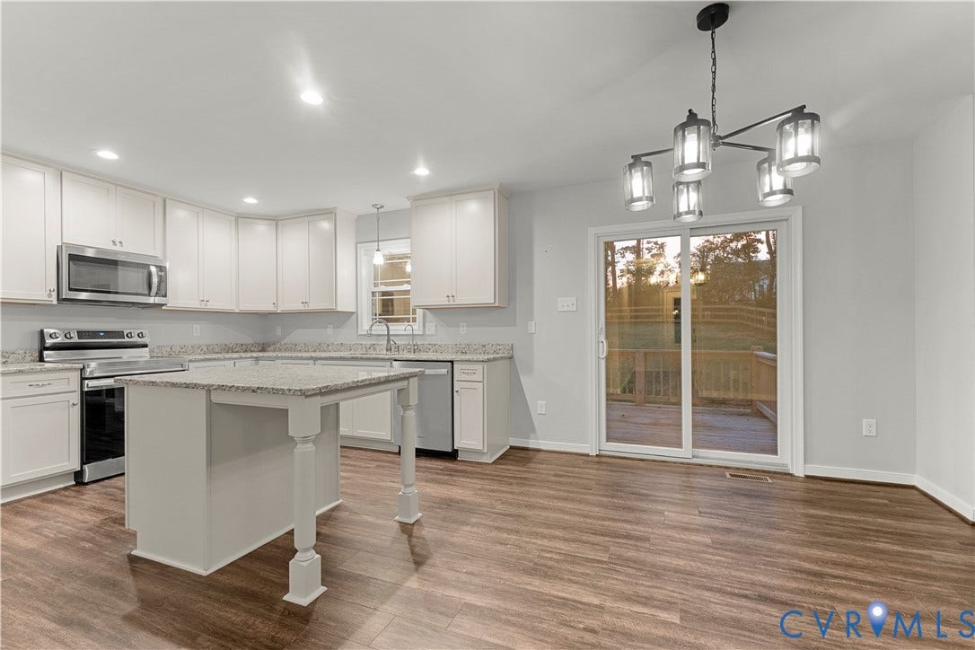 2953 Preston Park Court, Western Goochland County, Goochland, VA 23153 Kitchen featuring white cabinetry, stainless steel appliances, a center island with a light-toned countertop, and wood-finish flooring