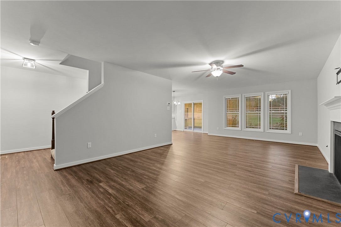 2953 Preston Park Court, Western Goochland County, Goochland, VA 23153 Spacious room featuring wood-finish flooring, a ceiling fan with integrated lighting, a fireplace with a mantel, and multiple windows