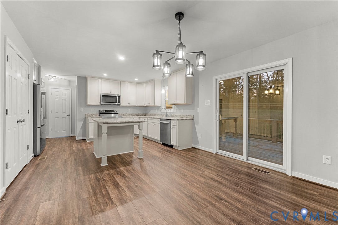 2953 Preston Park Court, Western Goochland County, Goochland, VA 23153 Kitchen featuring wood-finish flooring, white cabinetry, a central island, stainless steel appliances, and sliding glass doors to exterior