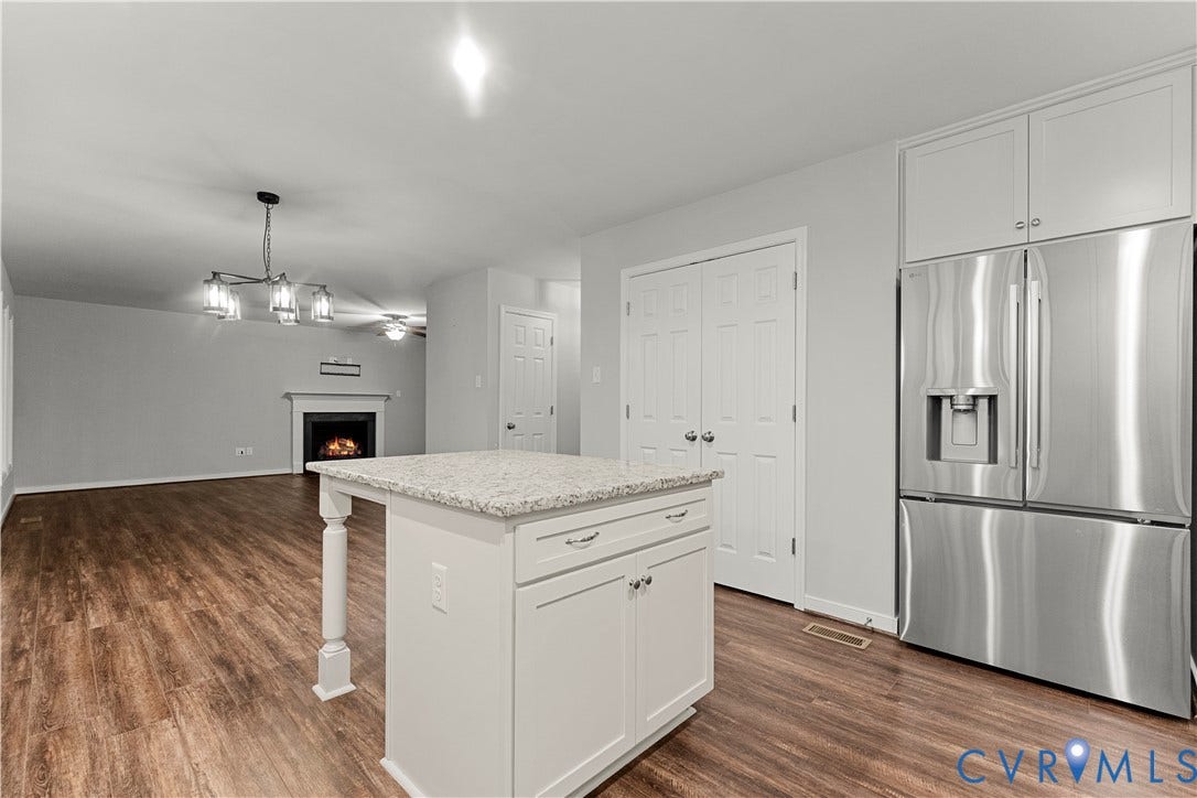 2953 Preston Park Court, Western Goochland County, Goochland, VA 23153 Modern kitchen featuring stainless steel French-door refrigerator with ice and water dispenser, white cabinetry with brushed nickel hardware, and granite-look countertop island with waterfall edge