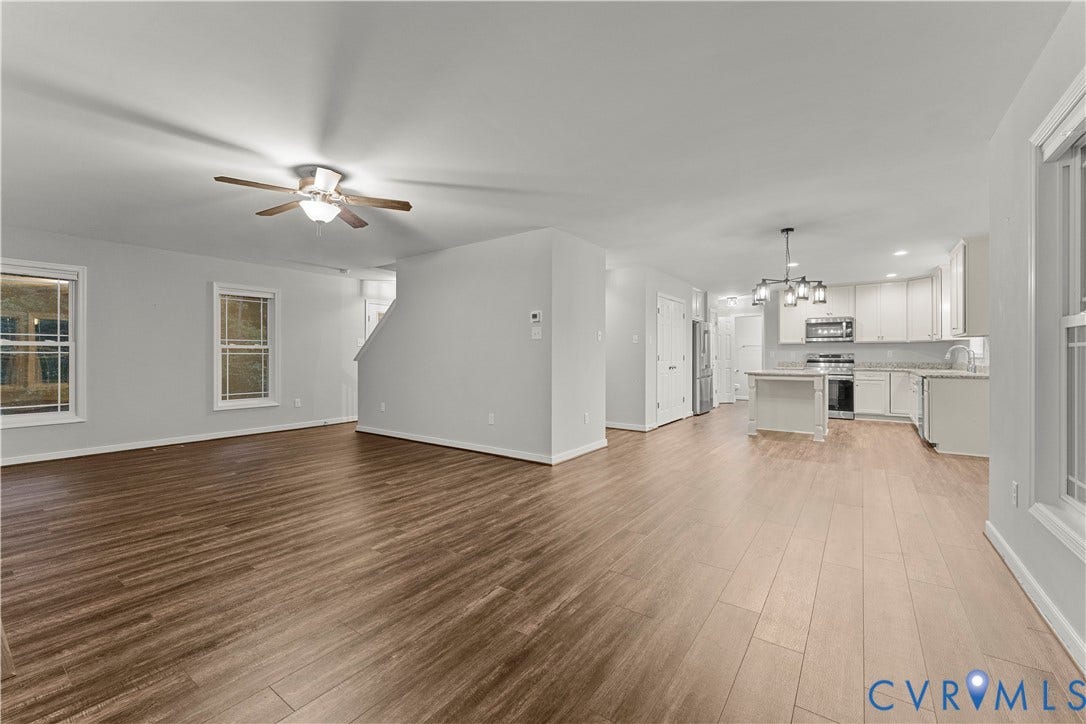 2953 Preston Park Court, Western Goochland County, Goochland, VA 23153 Open-concept living area with wood-finish flooring, a contemporary kitchen, white cabinetry, a kitchen island, and stainless steel appliances