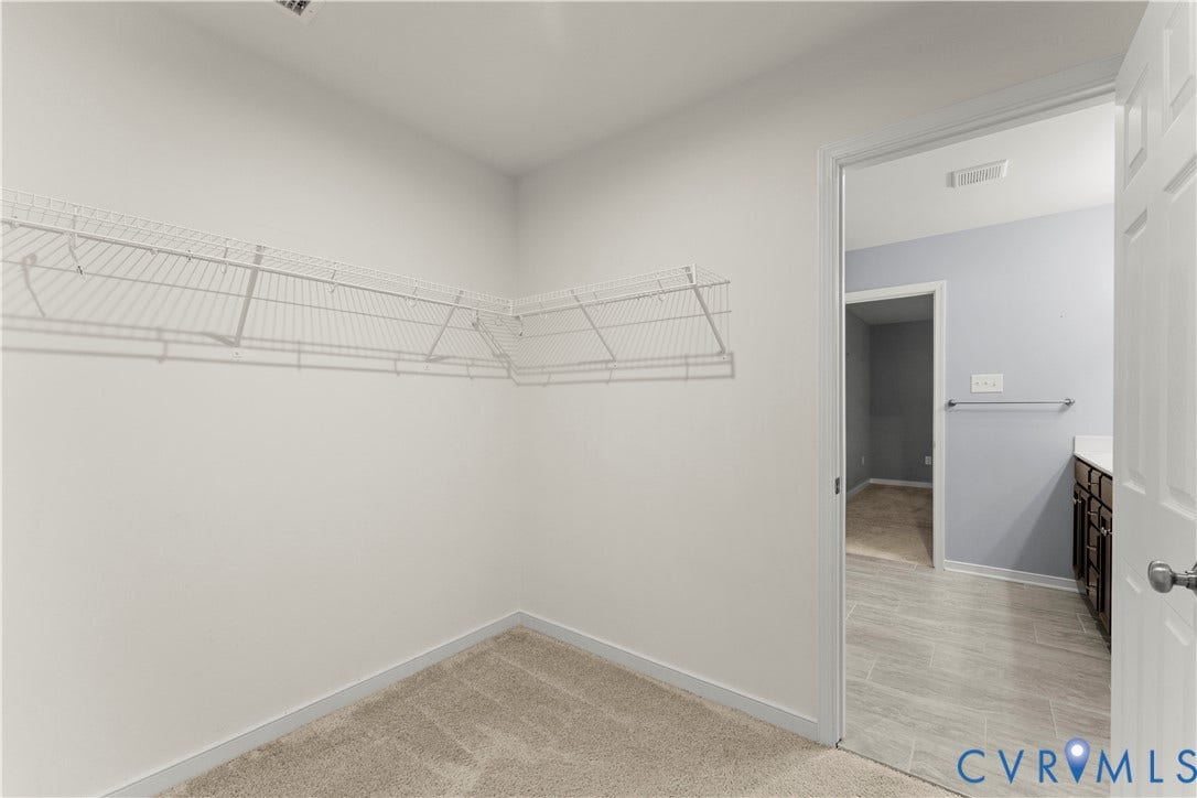 2953 Preston Park Court, Western Goochland County, Goochland, VA 23153 Spacious walk-in closet featuring wire shelving system, neutral carpeting, and direct access to the adjoining room through a glass-panel door