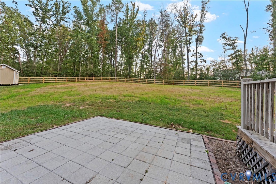 2953 Preston Park Court, Western Goochland County, Goochland, VA 23153 Multi-level rear exterior featuring a wood deck, paver patio, wood split-rail fencing, and a gravel driveway