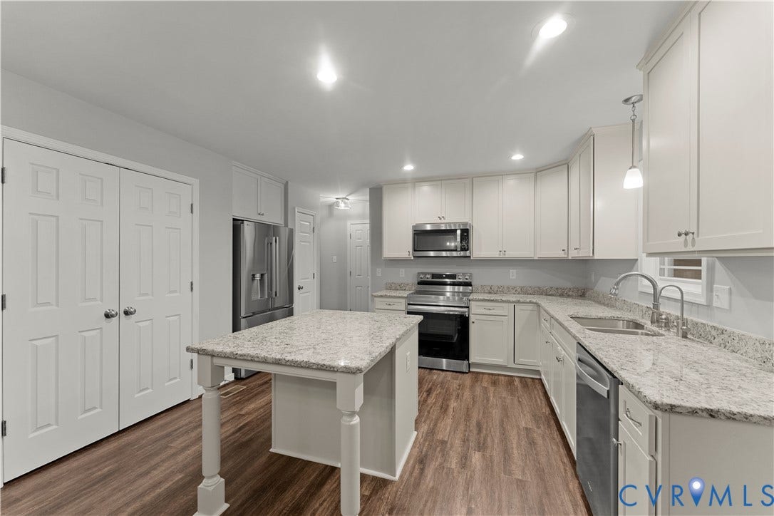 2953 Preston Park Court, Western Goochland County, Goochland, VA 23153 Kitchen featuring white cabinetry, light-toned countertops, wood-finish flooring, a stainless steel appliance suite, and a center island
