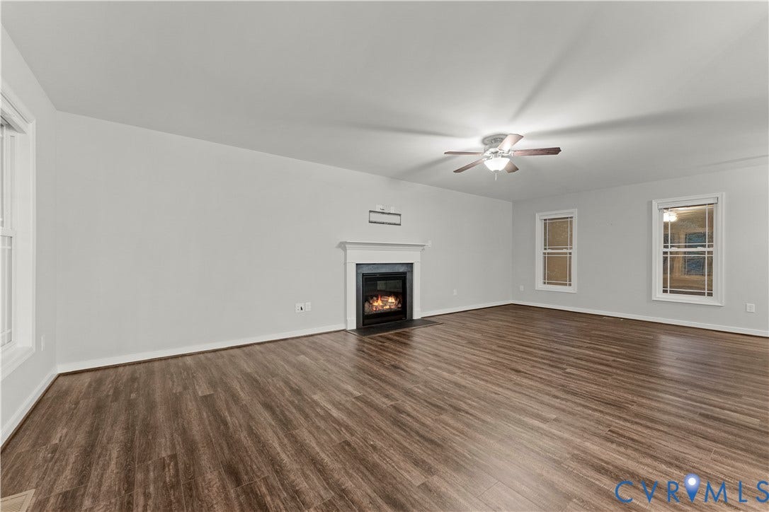 2953 Preston Park Court, Western Goochland County, Goochland, VA 23153 Living space featuring wood-finish flooring, a fireplace with a white mantel, multiple windows, and a ceiling fan with integrated lighting
